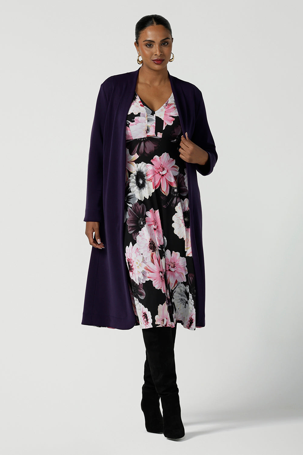 Back view of a size 10 woman wears the Tracey Dress in Night bloom. A Empire Line Dress with a floral print on a black base. Comfortable jersey design. Made in Australia for women size 8-24. Petite to plus size women. Styled back with a Sorel Trenchcoat in Purple