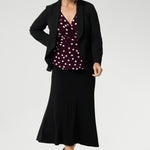 Our mature-aged model wears this elegant women’s workwear top, designed with a flattering peplum silhouette and a dipped back hem for added coverage and a feminine finish. Proudly Australian made from a dry-touch jersey fabric, this style is available in sizes 8–24. Style with Merit Blazer in Black & Asher Skirt in Black.
