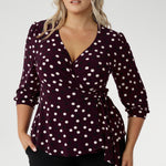 The Tristan wrap top is thoughtfu lly designed for both comfort and style. Featuring a flattering peplum silhouette, its hemline dips gracefully at the back, offering extra coverage and a feminine touch. Crafted from a dry touch jersey base with a timeless spotted design. Available in sizes 8-24.