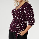 The Tristan wrap top is thoughtfu lly designed for both comfort and style. Featuring a flattering peplum silhouette, its hemline dips gracefully at the back, offering extra coverage and a feminine touch. Crafted from a dry touch jersey base with a timeless spotted design. Available in sizes 8-24.