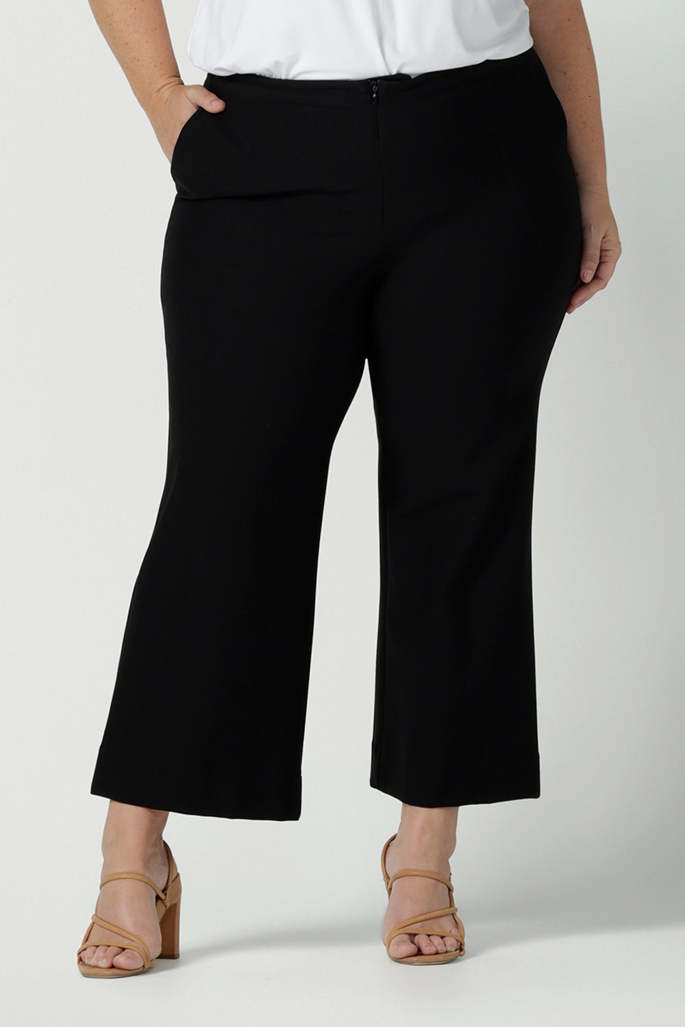 Close up of Tobie pants for curvy women, these flared leg, cropped pants are tailored for smart casual office wear. Worn with a V-neck, short sleeve top in white, and shown on a size 18 woman, these plus size black pants are made in Australia by Australian and New Zealand women's clothing brand, Leina & Fleur. Shop quality pants in sizes 8 to 24 in their online fashion boutique!