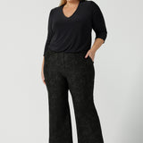 A size 18 woman wears Grey Leopard printed Ponte Troy Pants. A kick flare pant in a fashionable on trend leopard print paired back with a Vida top in Charcoal. Made in Australia for women size 8 - 24.