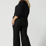 Back view of a size 18 woman wears Grey Leopard printed Ponte Troy Pants. A kick flare pant in a fashionable on trend leopard print paired back with a Vida top in Charcoal. Made in Australia for women size 8 - 24.