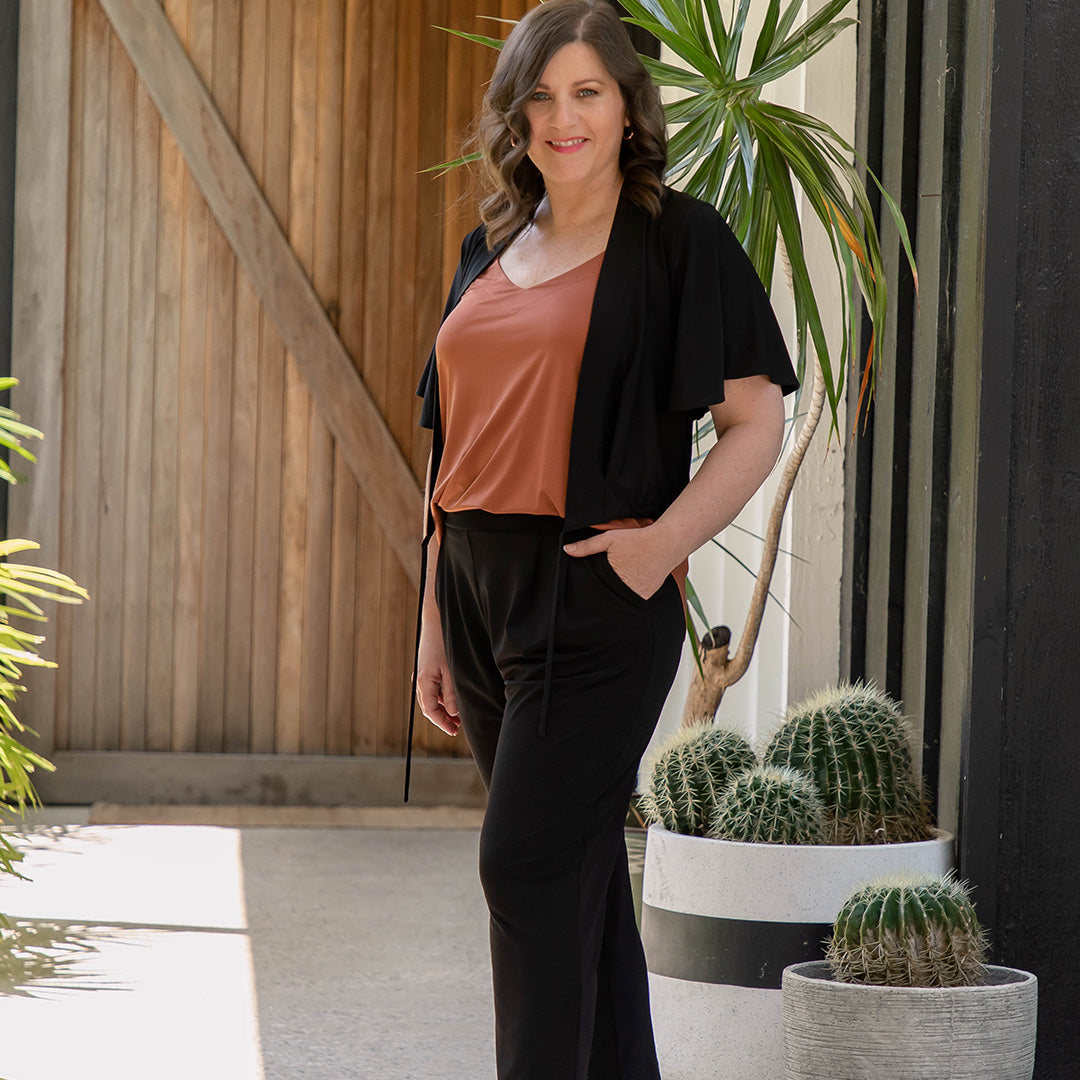 Showing good pants for petite height women, a curve woman wears black jersey pants with pockets. by Australian and New Zealand clothing brand, Leina & Fleur. 