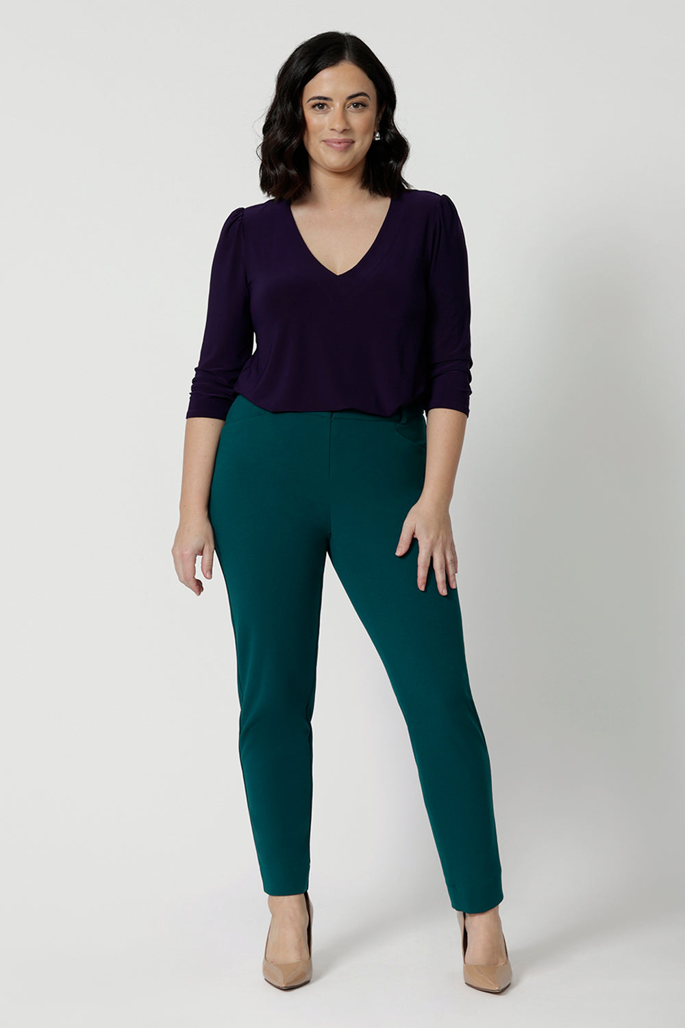 A good workwear outfit for petite height women, a size 12 woman wears tapered leg, green work pants with a 3/4 jersey top in amethyst purple. Good pants for work, these trousers are made from stretchy jersey and are comfortable for all-day wear. Made in Australia by Australian and New Zealand women's clothes label, Leina & Fleur, shop easy-care workwear for petite to plus size women. 