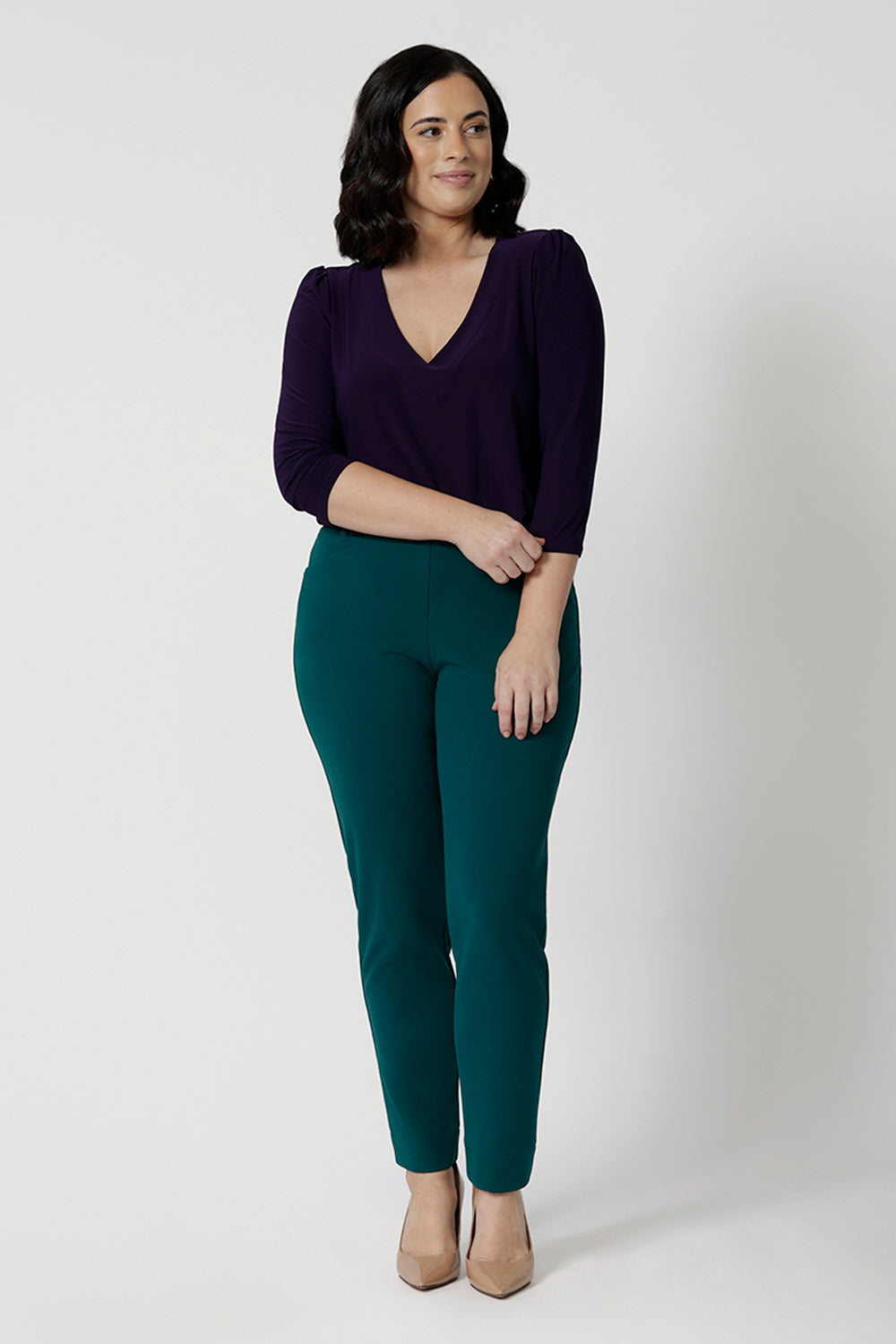 If you're looking for women's work tops look no further than the Vida Top in Amethyst! A V-neck top with 3/4 sleeves, this purple jersey top is worn with tapered leg workwear pants in green. Wear this top with workwear separates as an office top or dress down with casual pants as a comfortable top for the weekend. Made in Australia by Australian and New Zealand women's clothes brand, Leina & Fleur. 