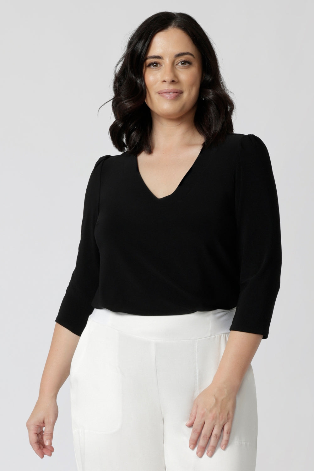 Size 10 woman wearing the Vida top in Navy that has a  V-neckline and 3/4 sleeve. Comfortable dry touch jersey top for corporate workwear to weekend. Made in Australia for women sizes 8-24.