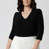 Size 10 woman wearing the Vida top in Navy that has a  V-neckline and 3/4 sleeve. Comfortable dry touch jersey top for corporate workwear to weekend. Made in Australia for women sizes 8-24.