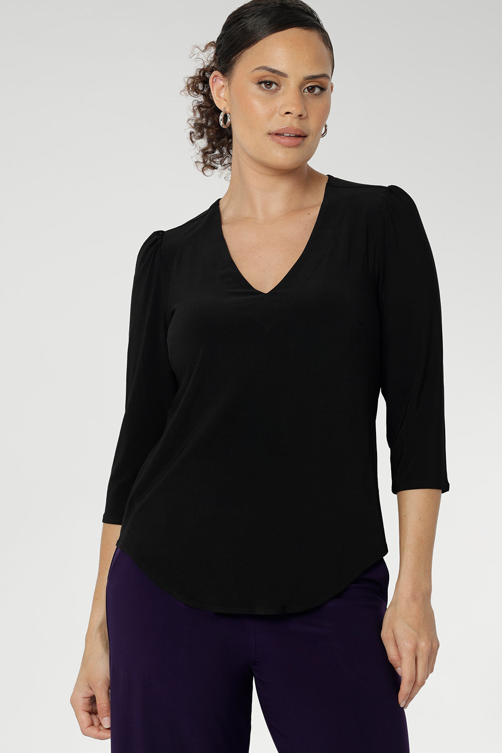 Size 10 woman wearing the Vida top in black that has a V-neckline and 3/4 sleeve. Comfortable dry touch jersey top for corporate workwear to weekend. Made in Australia for women sizes 8-24.