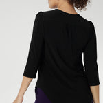 Size 10 woman wearing the Vida top in black that has a V-neckline and 3/4 sleeve. Comfortable dry touch jersey top for corporate workwear to weekend. Made in Australia for women sizes 8-24.