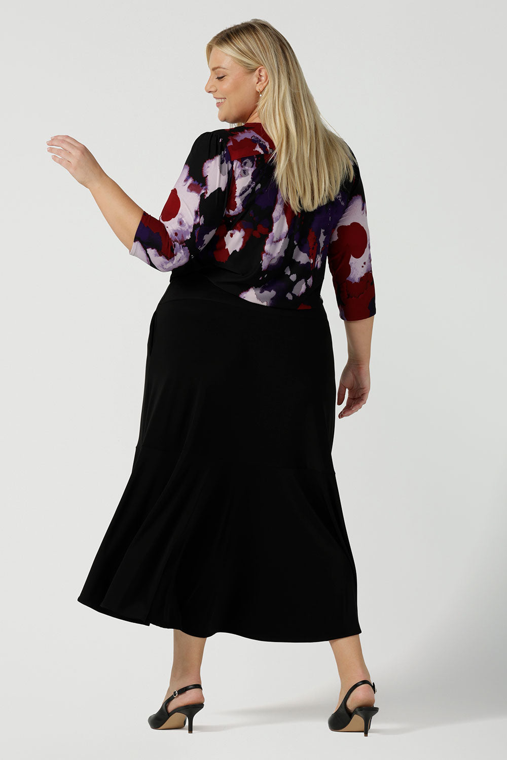 Back view of a size 18 woman wears the Vida top in Fitzroy with a V-neckline and 3/4 sleeve. Curved hemline and comfortable workwear for women made in Australia for women size 8 to 24.