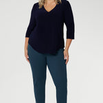 A plus-size model wears the Vida Top in timeless Navy, featuring a flattering V-neckline and 3/4 sleeves that offer the perfect balance of coverage and style. Made from our signature dry-touch stretch jersey, this top delivers exceptional comfort and a polished look.
