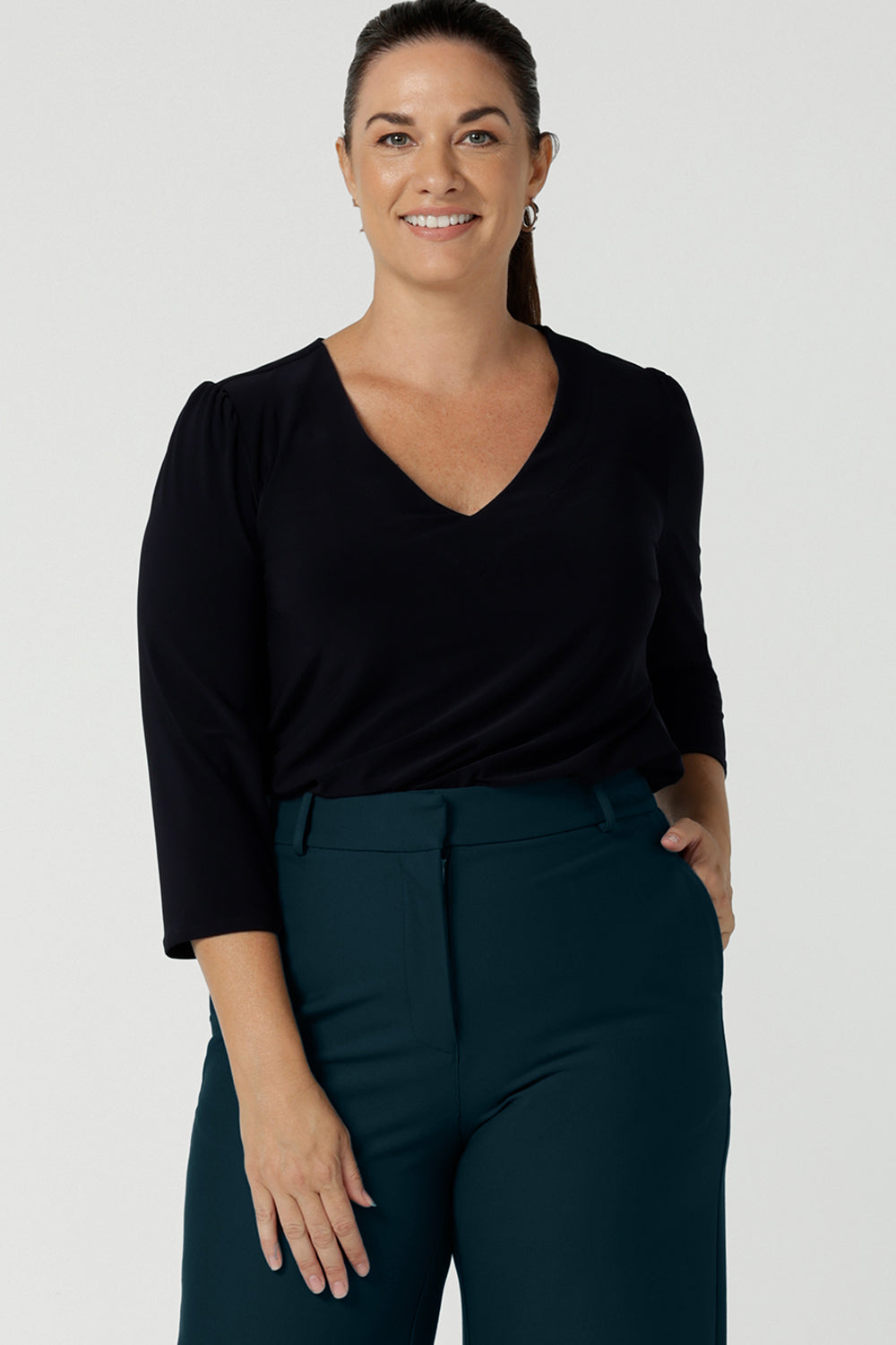 Close up of a size 12 woman wearing the Vida top in Navy with a V-neckline and 3/4 sleeve. Comfortable jersey top for corporate workwear to weekend. Made in Australia for women size 8 -24.