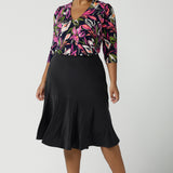 Size 16 Women wears the Berit skirt in Charcoal with pockets and tier hem. A great below knee length skirt perfect for all heights especially petite. Made in Australia for women size 8 - 24. Styled back with the Vida to in Vivid floral a bright and bold floral print on a navy base.