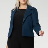 Plus size woman wears knit top under her Garcia Jacket in Petrol. Designed for comfort and versatility, it features a flattering close-to-body fit that moves with you, thanks to its generous stretch and breathable finish. Black knit top has thumbholes that can be used or tucked away for versatility in styling and extra warmth. Available in size 8-24.