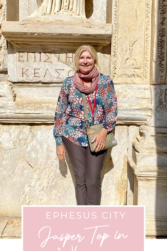 Loyal customer of Australian and New Zealand women's clothing label, L&F, Susan wears olive, slim pants and long, bishop sleeve jersey top in pretty floral print, and pink bamboo jersey scarf in Ephesus Ancient City, as part of her guide for 40 plus women on what clothes to pack for your travel holiday.