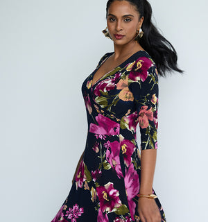 Showing good outfits for wedding guests, the image features a floral print, fixed wrap reversible dress with 3/4 sleeves as a wedding outfit by Australian and New Zealand women's fashion brand, Leina & Fleur. Wearing 