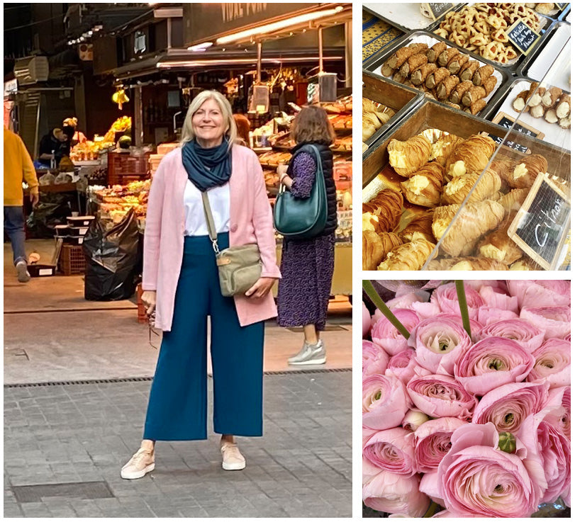 Image of an Australian woman wearing wide leg, cropped pants in petrol green jersey, a white bamboo jersey, pink cardigan and green bamboo jersey scarf, all by Australian and New Zealand women's clothing label, L&F, as part of her guide to the ultimate capsule travel wardrobe. She is wearing L&Fs comfortable travel clothing in Barcelona at a food and flower market. 