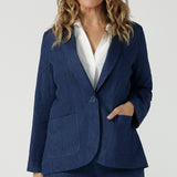 A size 10 woman wears the Vintage Denim Xavier Blazer. A button front style blazer with pockets. Made in Australia for women size 8-24