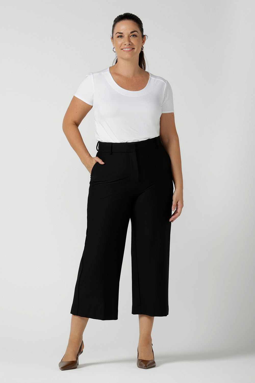 Size 12 woman wears Yael culotte in black. High waist tailored pant with pockets and fly front. Comfortable corporate work pants in culotte length. Petite heigh friendly. Made in Australia for women size 8 - 24.