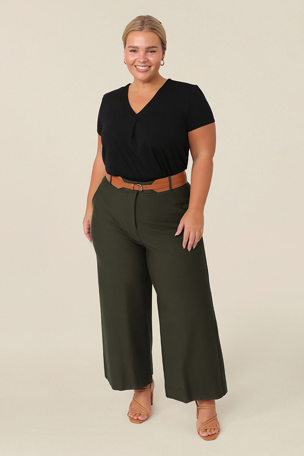 Good pants for petite women, these are wide leg, cropped, tailored workwear pants. Worn by a petite height, size 16 curvy woman, together with a short sleeve, black top and tan belt, these are great workwear pants Made in Australia, in stretch jersey, these work trousers have a comfortable fit.