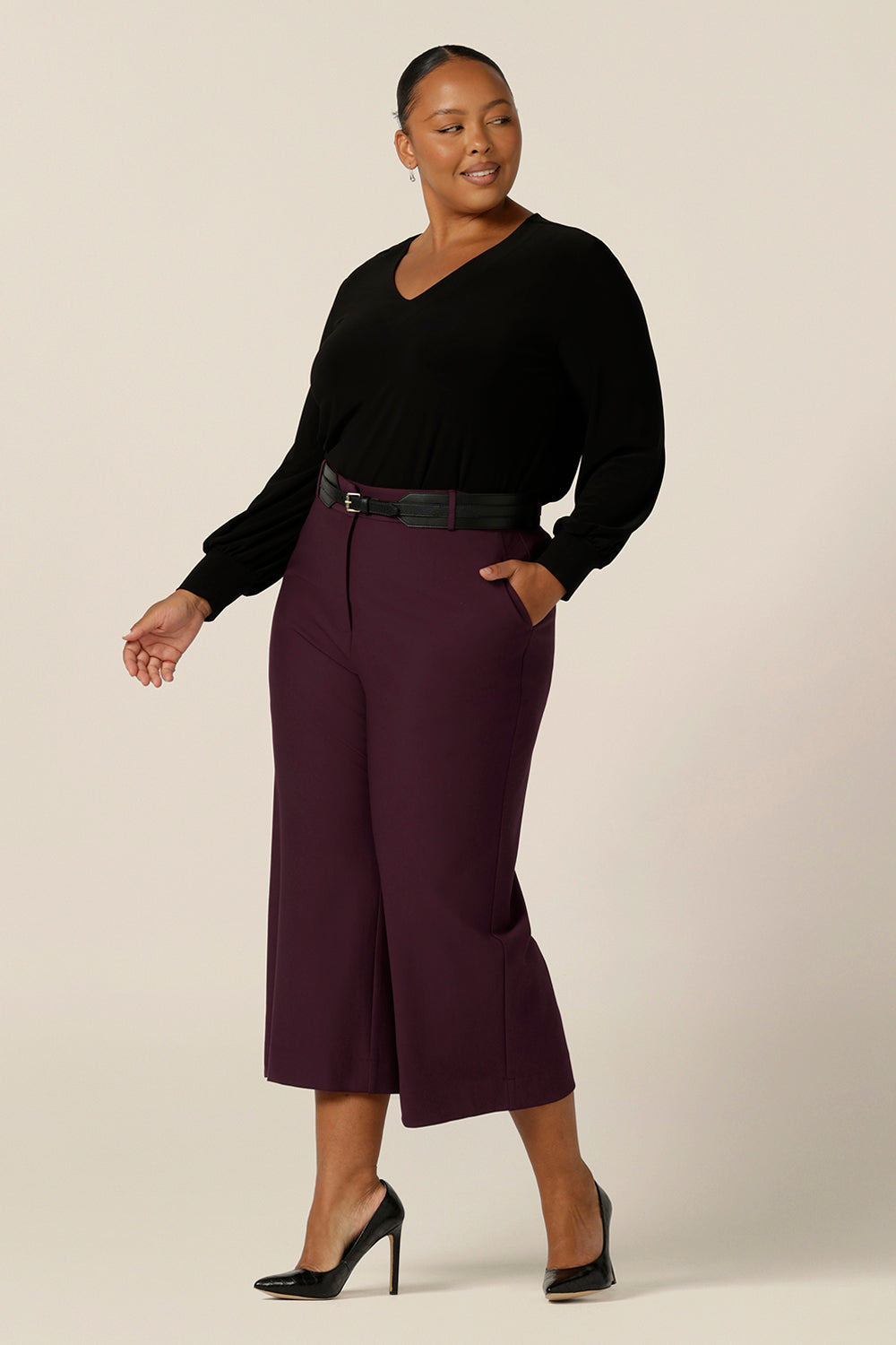 Modern workwear trousers - a size 18, curvy woman wears wide leg, cropped length, tailored pants in Mulberry ponte jersey with a long sleeve, V neck top in black jersey. Made in Australia by Australian and New Zealand women's clothing label, L&F, these easy care pants work for corporate wear and weekend wear