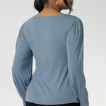 The boat neckline frames the collarbone with subtle sophistication, while tailored bust darts and a close-to-body shape enhance the fit without feeling restrictive. Crafted with attention to detail, the full-length sleeves feature gentle gathers at the shoulder and a wrist dart, adding soft volume and movement—ideal for styling under outerwear without bulk.