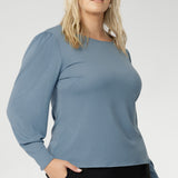 The Zara knit top, a refined yet relaxed essential designed for cool-weather layering. With its modern silhouette and graceful bellow sleeves, this piece delivers understated elegance and all-day comfort. The boat neckline frames the collarbone with subtle sophistication, while tailored bust darts and a close-to-body shape enhance the fit without feeling restrictive.