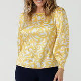 A size 10 woman wears a Zara Top in Yellow Swirl silk. A long sleeve blouse with fashion sleeve and made in 100% silk. Made in Australia for women size 8-24