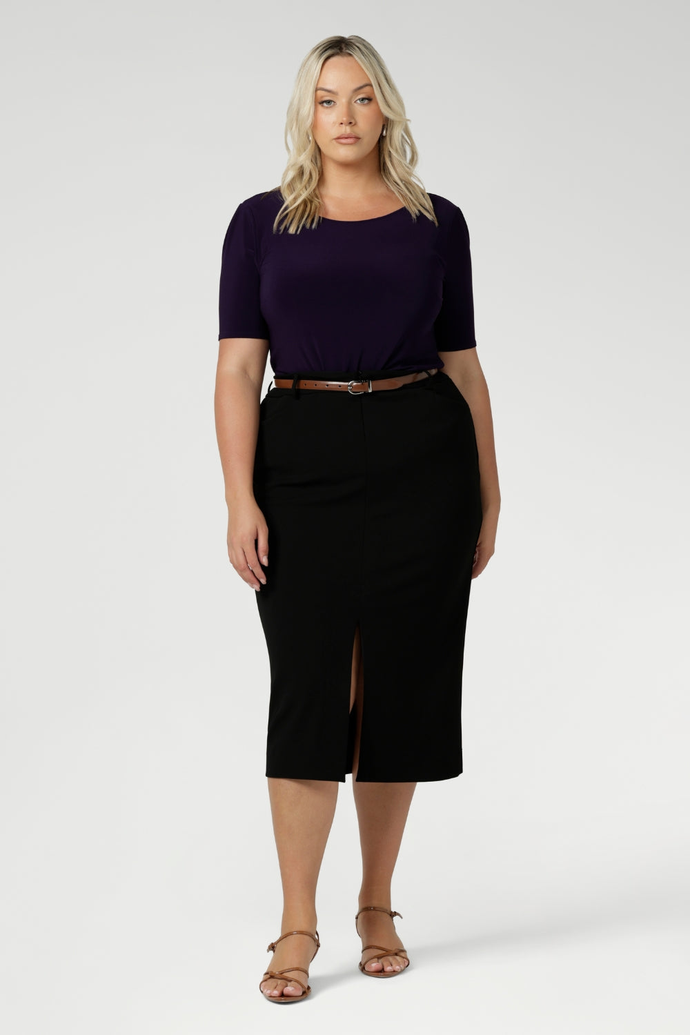 A good work top for plus size women, this is a boat neck top in amethyst jersey is worn with black, midi length skirt, paired with brown heels and brown belt. Full of stretch this comfortable top is easy to wear and is made of easy-care fabric. Made in Australia by Australian and New Zealand women's clothes brand, Leina & Fleur. Available in sizes 8-24.