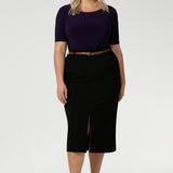 A good work top for plus size women, this is a boat neck top in amethyst jersey is worn with black, midi length skirt, paired with brown heels and brown belt. Full of stretch this comfortable top is easy to wear and is made of easy-care fabric. Made in Australia by Australian and New Zealand women's clothes brand, Leina & Fleur. Available in sizes 8-24.