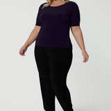 A good work top for plus size women, this is a boat neck top in amethyst jersey is worn with black, tapered leg pants. Full of stretch this comfortable top is easy to wear and easy-care. Made in Australia by Australian and New Zealand women's clothes brand, Leina & Fleur, shop tops for petite to plus size women online.