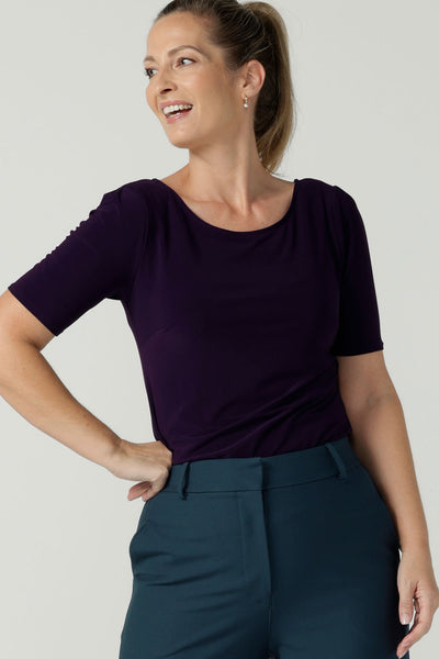 Size 10 woman wears the Ziggy top in Amethyst. Round neckline top with elbow length sleeves, sleeve head tuck. Soft comfortable jersey for stylish workwear. Made in Australia size 8 to 24.