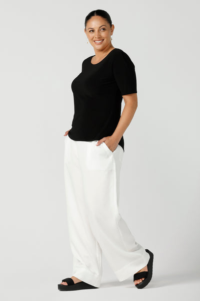 A curvy size 12 woman wears a jersey Ziggy top with a round neckline and elbow-length sleeve and curved hemline. The perfect work top for comfortable corporate wear. Made in Australia for Australian fashion label Leina & Fleur sizes 8 -24.