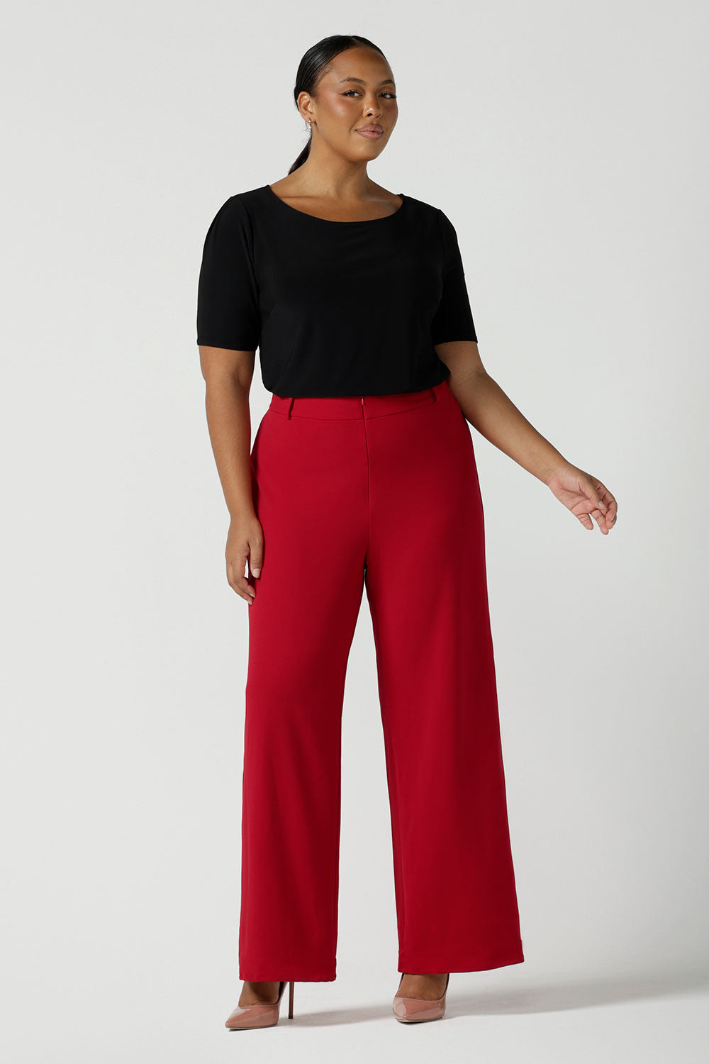 Size 16 woman wears the Drew pant in red, high waist and invisible fly front. Tailored belt loops and wide leg. Made in Australia for women. Stylish corporate wear for women. Made in Australia size 8 - 24. 