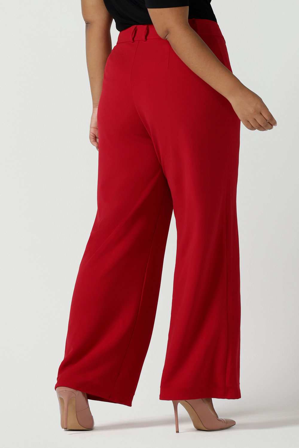 Back view of a size 16 woman wears the Drew pant in red, high waist and invisible fly front. Tailored belt loops and wide leg. Made in Australia for women. Stylish corporate wear for women. Made in Australia size 8 - 24.