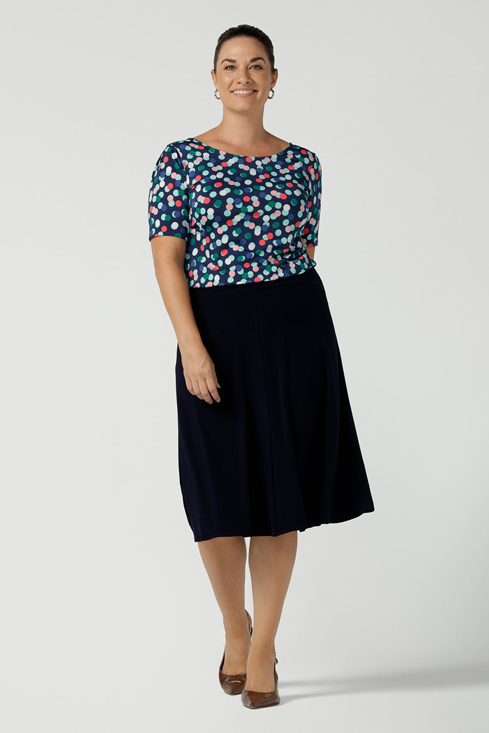 Size 12 woman wears Ziggy Top in Blue Bubbles. A boat neckline style made in soft jersey with a above elbow sleeve and double turned neckline. Style back with Navy Berit skirt. Made in Australia for women size 8 - 24.