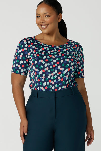 Size 16 curvy woman wears Ziggy Top in Blue Bubbles. A boat neckline style made in soft jersey with a above elbow sleeve and double turned neckline. Styled back with Petrol Yael tailored pants. Made in Australia for women size 8 - 24.