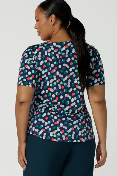Back view of size 16 curvy woman wears Ziggy Top in Blue Bubbles. A boat neckline style made in soft jersey with a above elbow sleeve and double turned neckline. Styled back with Petrol Yael tailored pants. Made in Australia for women size 8 - 24.