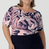 Curvy woman wears the Ziggy top in a size 18 with a boat neckline, elbow length sleeves and an abstract print on a Navy base. With painterly brush strokes. Styled back with the Andi tube skirt in Navy. Size 8 - 24.