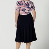 Back view of a size 12 woman wears the Ziggy top with a boat neckline, elbow length sleeves and an abstract print on a Navy base. With painterly brush strokes. Styled back with the Andi tube skirt in Navy. Inclusive sizing for women Size 8 - 24