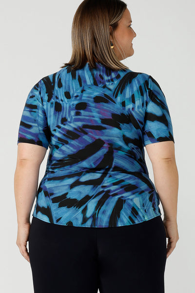 Back view of a curvy size 18 woman wears boat neckline Ziggy top in Flutter. A cobalt and purple print on a black base that is digitally printed. Made in Australia in soft Jersey with elbow length sleeves. A great work to weekend top. Size 8 - 24.