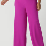 Close up of a size 16 Woman wears the Drew Pant in Fuchsia. A high waist tailored pant with matching suit blazer. Made in Australia for women size 8 - 24.