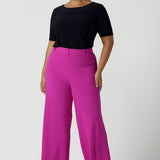 Size 16 Woman wears the Drew Pant in Fuchsia. A high waist tailored pant with matching suit blazer. Made in Australia for women size 8 - 24. 