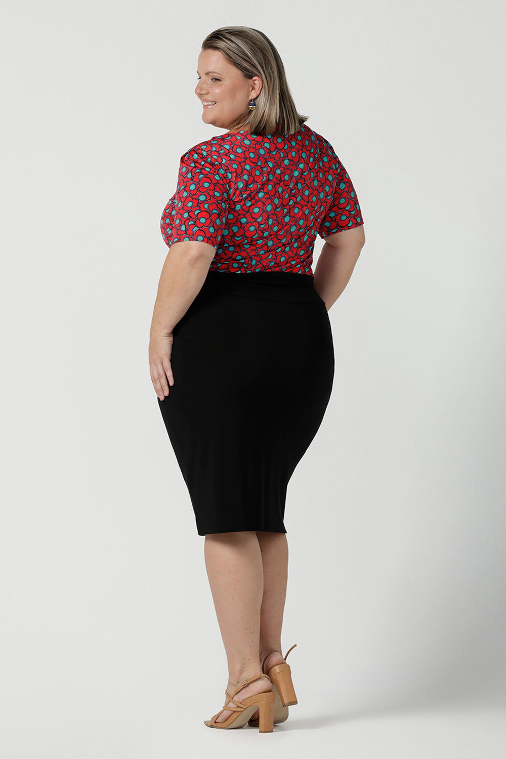 Back view of a size 12 woman wears the Ziggy top in Rio with a red base and seventies style floral. Round and conservative neckline. Short sleeve and made in Australia for women size 8 - 24.