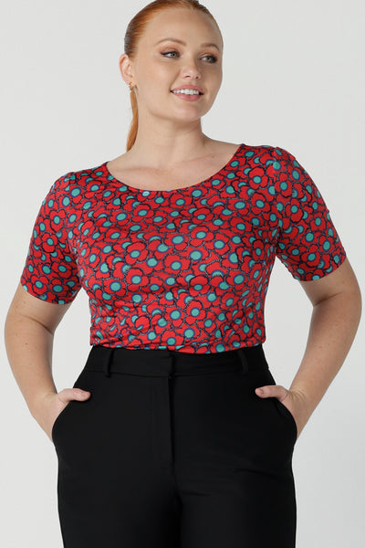 Size 12 woman wears the Ziggy top in Rio with a red base and seventies style floral. Round and conservative neckline. Short sleeve and made in Australia for women size 8 - 24.