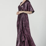 A size 10 woman wears a glamorous wrap dress for cocktail wear. Made in Australia wit pink foil mikado fabric with detailed design and flutter with with tears. Low neckline and flattering for all shapes petite to plus size ladies clothing. Made in Australia for women size 8 - 24.