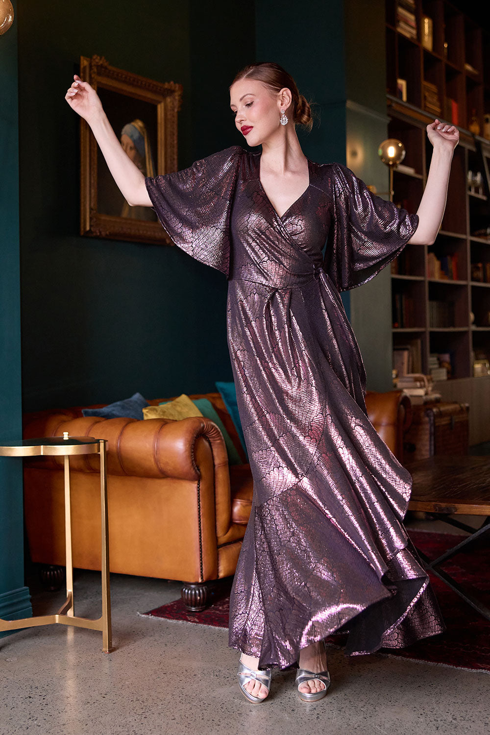 A size 10 woman wears a glamorous wrap dress for cocktail wear. Made in Australia wit pink foil mikado fabric with detailed design and flutter with with tears. Low neckline and flattering for all shapes petite to plus size ladies clothing. Made in Australia for women size 8 - 24. 