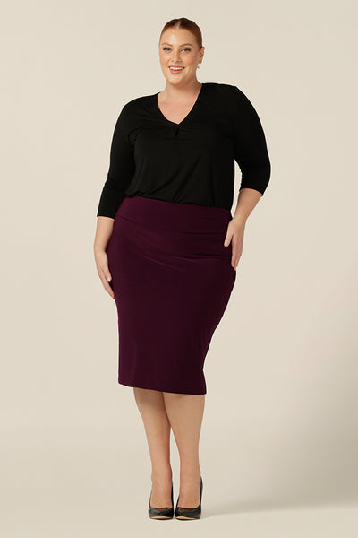 A size 18, fuller figure woman wears a Mulberry tube skirt in stretch jersey. A knee-length pencil skirt, the stretch fabric makes for a comfortable skirt for work and corporate wear.