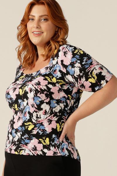 Side view of a size 18 curvy woman wearing a printed jersey top with short sleeves and square scoop neckline. A good top for full busts, the Berni Top has a structured bust. This top is available to shop online in sizes 8 to size 24.